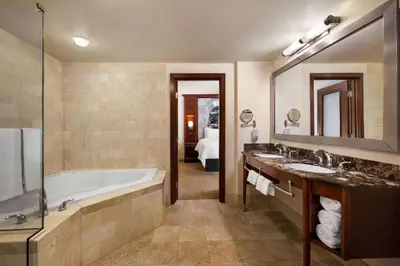 a bathroom with a tub and two sinks and a bath tub at Viana Hotel and Spa, Trademark Collection by Wyndham in Westbury