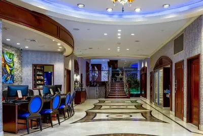 a lobby of a hotel with blue chairs and a staircase at Viana Hotel and Spa, Trademark Collection by Wyndham in Westbury