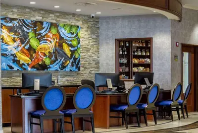 a lobby with a bar with chairs and a painting at Viana Hotel and Spa, Trademark Collection by Wyndham in Westbury