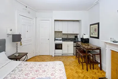 a living room with a bed and a kitchen at Modern Midtown East Apartments in NYC in New York