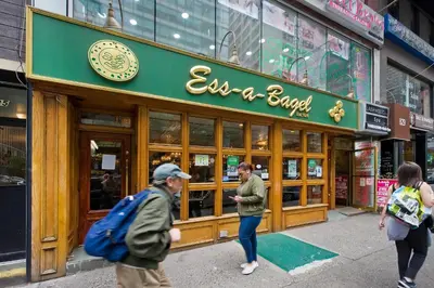 people walking in front of a restaurant on a street at Modern Midtown East Apartments in NYC in New York