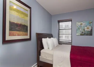a bedroom with a bed and a painting on the wall at Modern Midtown East Apartments in NYC in New York