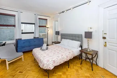a bedroom with a bed and a chair at Modern Midtown East Apartments in NYC in New York