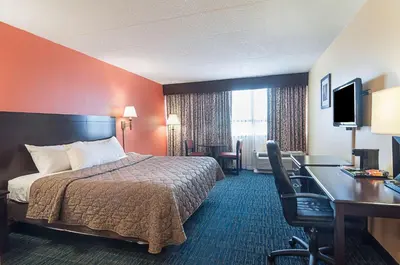 a hotel room with a bed and a desk at Rodeway Inn Meadowlands in Secaucus
