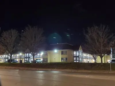 a building at night with trees in front of it at Travel Inn Motel in Hartford
