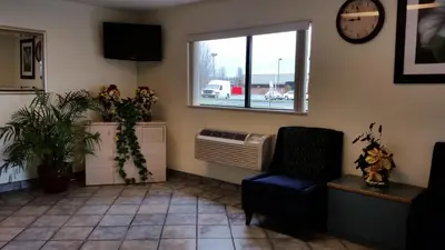 a waiting room with a chair and a window at Travel Inn Motel in Hartford