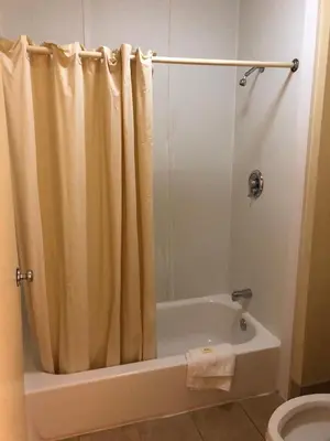 a bathroom with a shower curtain and a bath tub at Travel Inn Motel in Hartford