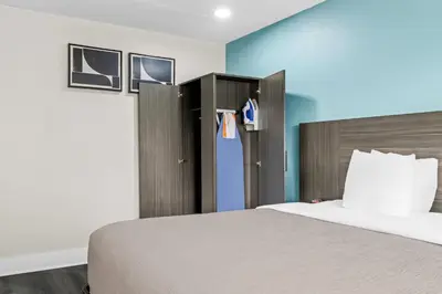 a bedroom with a bed and a blue wall at Quality Inn in West Haven