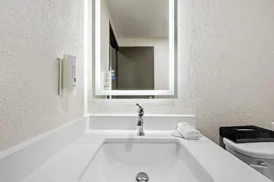 a white bathroom with a sink and a toilet at Quality Inn in West Haven