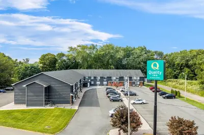 a building with a sign in front of a parking lot at Quality Inn in West Haven