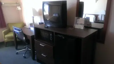 a hotel room with a desk with a television on it at Quality Inn in West Haven