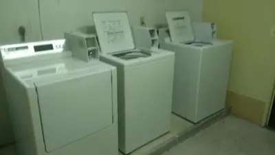 a group of three washers and dryers in a room at Quality Inn in West Haven