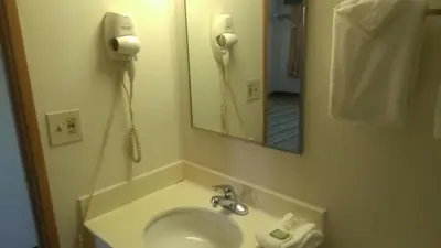 a bathroom with a sink and a phone on the wall at Quality Inn in West Haven