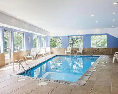 a swimming pool in a house with chairs at Comfort Inn Wethersfield - Hartford in Wethersfield