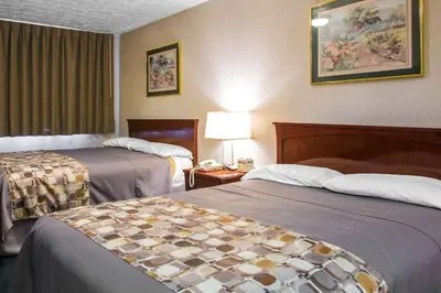 a hotel room with two beds and a lamp at Rodeway Inn & Suites Branford - Guilford in Branford