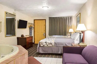 a hotel room with a bed and a bath tub at Rodeway Inn & Suites Branford - Guilford in Branford