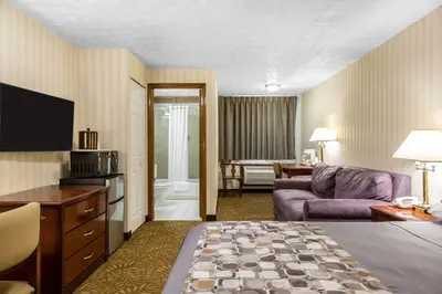 a hotel room with a couch and a living room at Rodeway Inn & Suites Branford - Guilford in Branford
