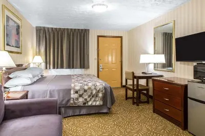 a hotel room with a bed and a desk at Rodeway Inn & Suites Branford - Guilford in Branford
