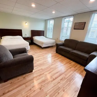 a living room with a bed and a couch and a bed and a couch at Baseball Town Motel in Cooperstown