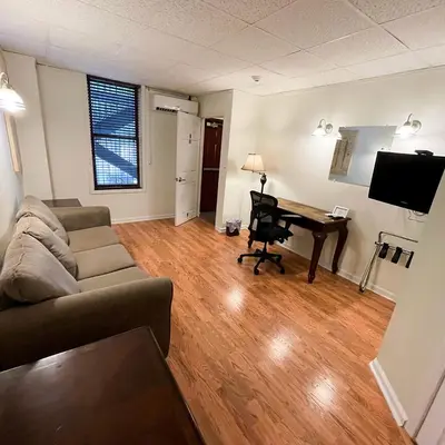 a living room with a couch and a desk at Baseball Town Motel in Cooperstown