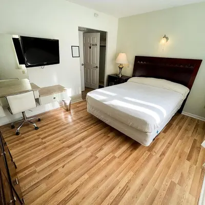 a bedroom with a bed and a flat screen tv at Baseball Town Motel in Cooperstown