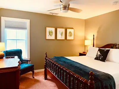 a bedroom with a bed and a chair and a window at The Nutmeg Vermont in Wilmington