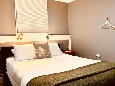 a bedroom with a bed with white sheets and a window at The Nutmeg Vermont in Wilmington