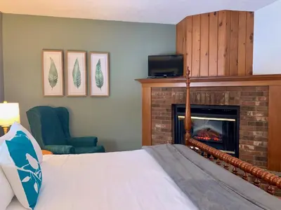 a bedroom with a bed and a fireplace at The Nutmeg Vermont in Wilmington