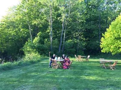 a group of people sitting at a table in the grass at The Nutmeg Vermont in Wilmington