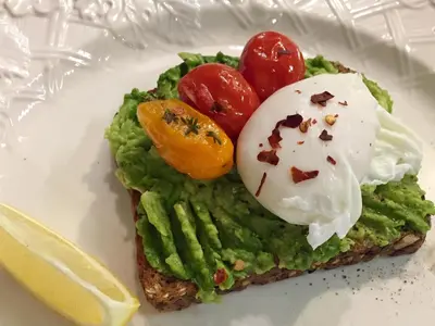 a piece of toast with avocado and tomatoes on a plate at The Nutmeg Vermont in Wilmington