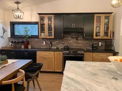 a kitchen with wooden cabinets and a table with chairs at Starlite Motel & Suites in Big Indian