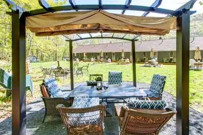 a patio with a table and chairs under an umbrella at Starlite Motel & Suites in Big Indian