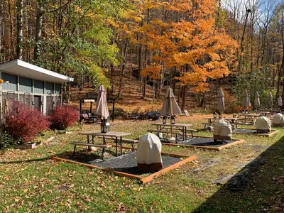a group of picnic tables with umbrellas in a park at Starlite Motel & Suites in Big Indian