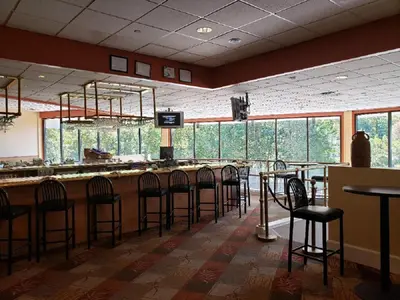 a bar with a bunch of stools in a restaurant at Chateau Resort & Conference Center in Tannersville