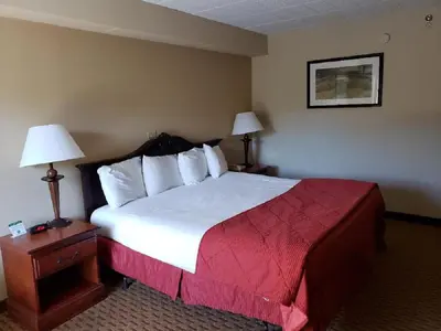 a hotel room with a large bed and two lamps at Chateau Resort & Conference Center in Tannersville