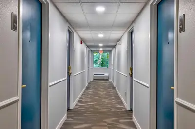 a corridor of an office hallway with blue doors at Motel 6 Bethel, CT - Danbury in Bethel