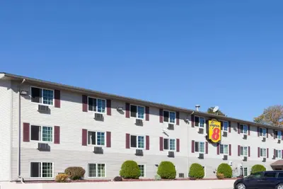 a large white building with red accents at Super 8 by Wyndham Johnstown/Gloversville in Johnstown