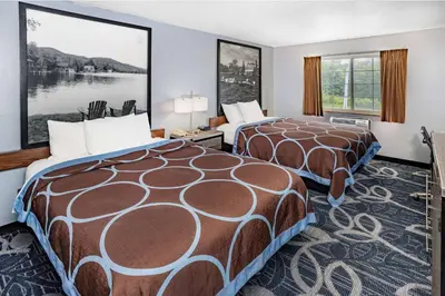 a hotel room with two beds and a large window at Super 8 by Wyndham Johnstown/Gloversville in Johnstown