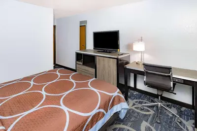 a hotel room with a bed and a desk and a television at Super 8 by Wyndham Johnstown/Gloversville in Johnstown