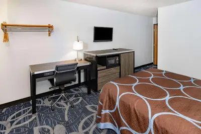 a hotel room with a desk and a bed at Super 8 by Wyndham Johnstown/Gloversville in Johnstown