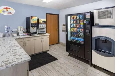 a kitchen with a refrigerator and a counter with drinks at Super 8 by Wyndham Johnstown/Gloversville in Johnstown