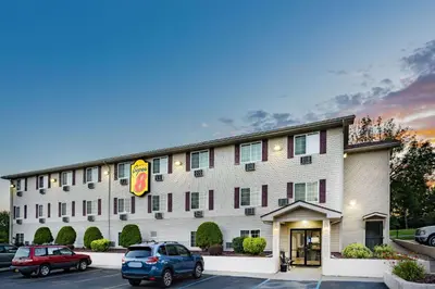a hotel with cars parked in a parking lot at Super 8 by Wyndham Johnstown/Gloversville in Johnstown