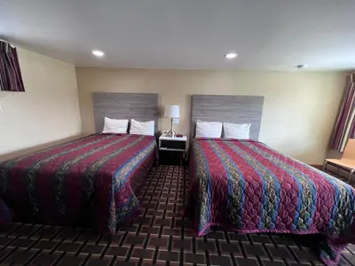 a hotel room with two beds and a table with a lamp at FairBridge Inn Express Milford in Milford