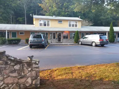 two cars parked in a parking lot in front of a building at FairBridge Inn Express Milford in Milford