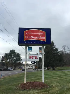 a sign for a motel on the side of a road at FairBridge Inn Express Milford in Milford