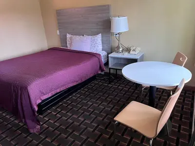a hotel room with a bed and a table and chair at FairBridge Inn Express Milford in Milford