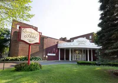 a building with a sign in front of it at The Queensbury Hotel in Glens Falls