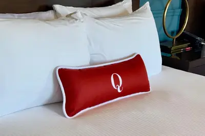 a red pillow sitting on top of a bed at The Queensbury Hotel in Glens Falls