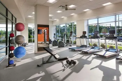 a gym with a lot of exercise equipment and windows at Homewood Suites By Hilton Teaneck Glenpointe in Teaneck