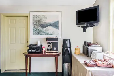 a room with a table and a tv on a wall at Knights Inn Hadley in Hadley